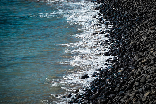 Beach of black volcanic rocks at the shore line. Lanzarote