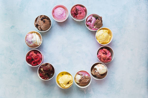 Different cups of ice cream flavors set in circle shape on rustic background with copy space