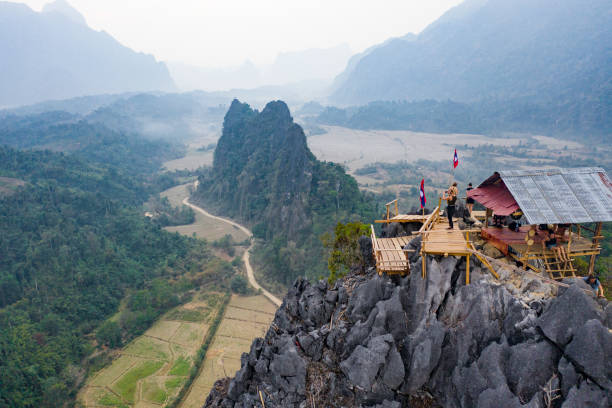 (visualizza dall'alto) splendida vista aerea di alcuni turisti che scattano foto nel bellissimo panorama dal punto di vista nam xay a vang vieng, in laos. - vang vieng foto e immagini stock