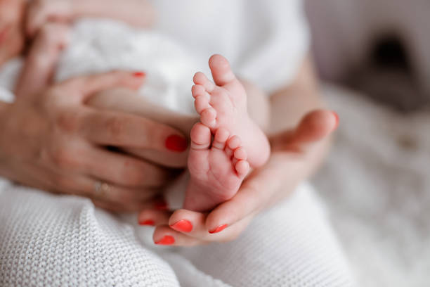 istock Baby legs in mother's hands 1130927602