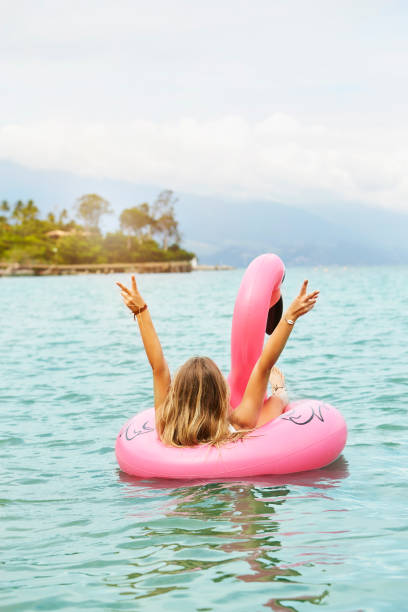 istock Girl in flamingo making peace sign 1130929150