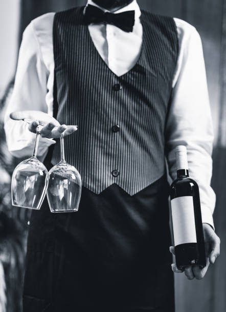 istock Midsection Of Bartendar Serving Wine In Bar 1130929728