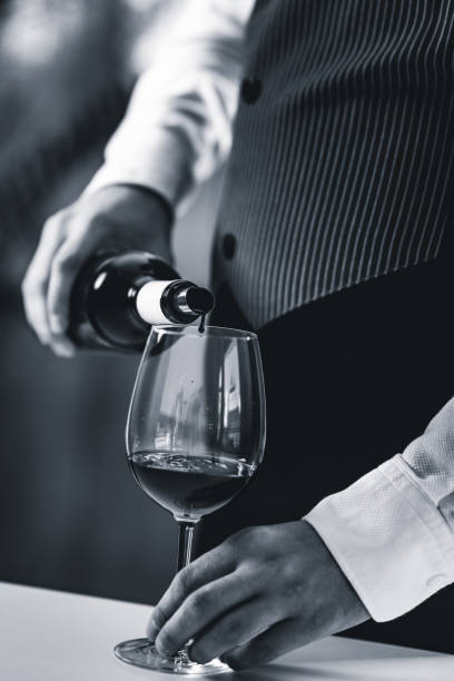 istock Midsection Of Bartendar Pouring Wine In Glass 1130929737