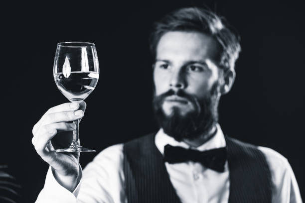 istock Bartendar Looking At Wineglass In Bar 1130929790