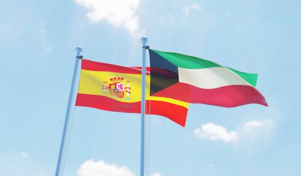 istock Kuwait and Spain, two flags waving against blue sky 1130932179