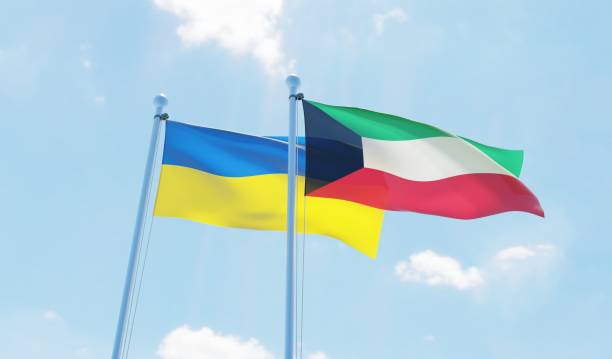 istock Kuwait and Ukraine, two flags waving against blue sky 1130932217
