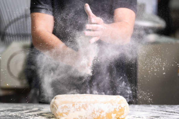 konditor klatscht seine hände mit mehl, während teig - bread kneading making human hand stock-fotos und bilder