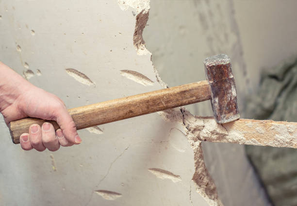 istock demolition work and rearrangement. worker with sledgehammer destroying wall 1130935667