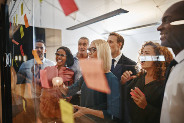 istock Diverse businesspeople brainstorming with notes on a glass wall 1130938054