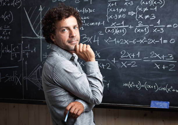 istock Portrait Of Teacher Standing By Blackboard 1130938873