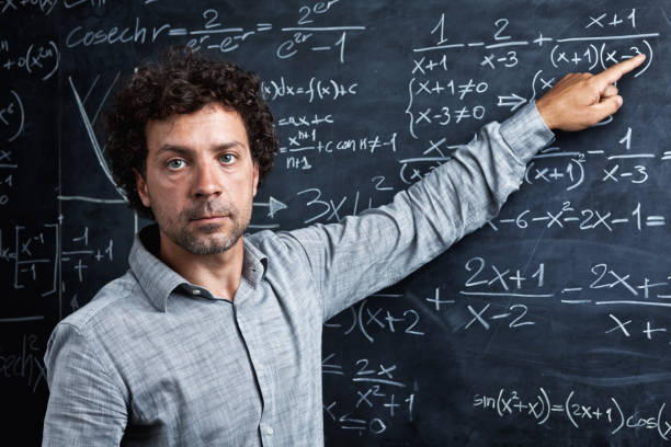 istock Portrait Of Teacher Pointing On Blackboard 1130938879