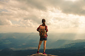 Rear View Of Woman Standing On Mountain Against Sky