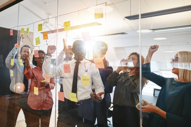 istock Ecstatic group of businesspeople cheering together during a brainstorming session 1130940582