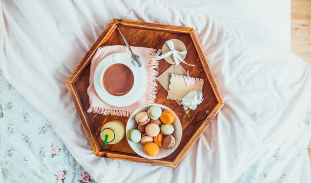 istock Breakfast in bed with empty blank card. Cup of coffee, juice, macaroons, flower and giftbox on wooden tray. Romantic breakfast in bed. Birthday, Valentine's day morning. Top view. Wide. Copy space. 1130942929