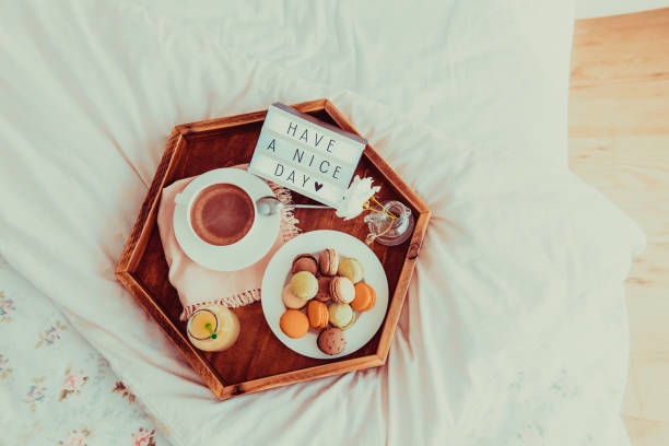 istock Top view Breakfast in bed with Have a nice day text on lighted box. Coffee, juice, macaroons, flower in vase on wooden tray. Good morning mood. Hospitality, care, service concept. Vintage tonning. 1130942974
