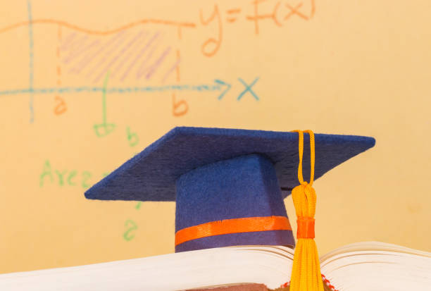 istock Education Graduate mortarboard blue hat on textbook with formula equation graph or Mathematics on screen, Ideas for knowledge learning success in study abroad international university, Back to School 1130945865