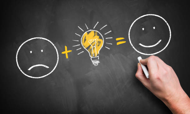 istock smiley with bad mood changes to happy smiley by having an idea, drawn on a chalkboard 1130946505
