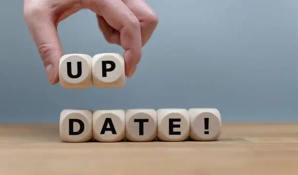 Dice form the word "UPDATE!" while a hand rises the letters "UP".