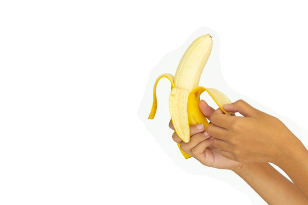 istock Banana open skin in hand on a white background isolation with clipping path 1130947884
