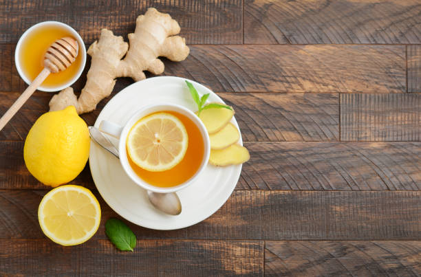istock Ginger root tea with lemon and honey on wooden background. 1130949255