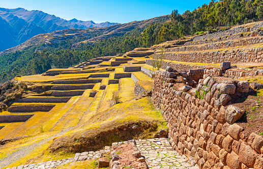 The beautiful Inca ruin of Chinchero with its giant agriculture terraces and Inca wall in the region of Cusco, Peru. The path underneath is a part of the Inca Trail going from Chinchero to Ollantaytambo.