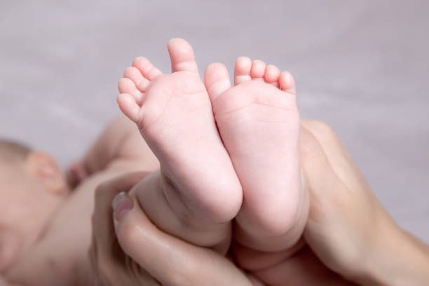 istock Baby legs in mother's hands 1130953237