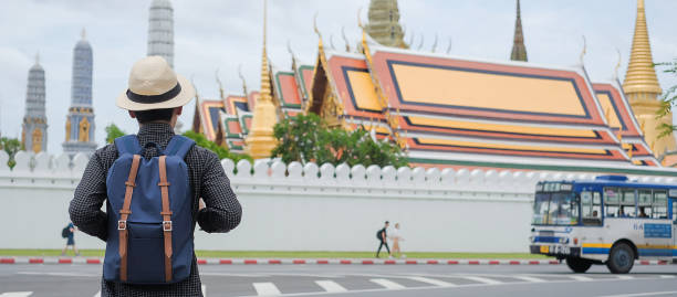 istock Rear View Of Man With Backpack Standing On Road In City 1130954394