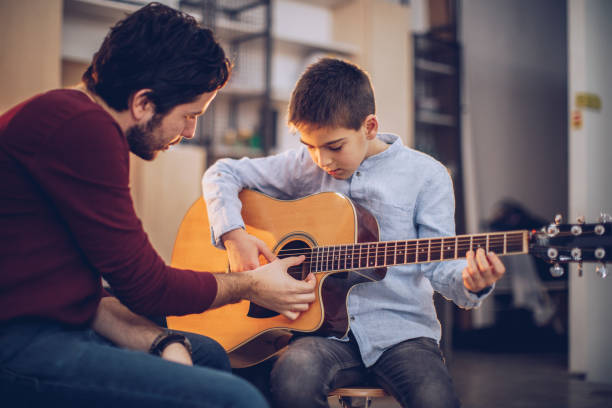 istock Guitar teacher teaching boy to play acoustic guitar 1130955921