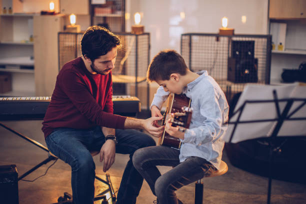 istock Guitar teacher teaching boy to play guitar 1130955945