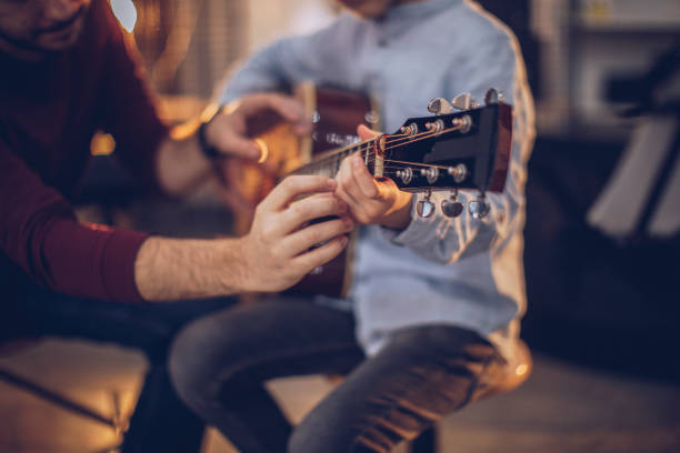 ragazzo alla scuola di chitarra con insegnante che impara a suonare - guitar child music learning foto e immagini stock