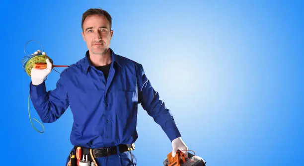 Photo of Background uniformed electrician with tools and electrical equipment half body