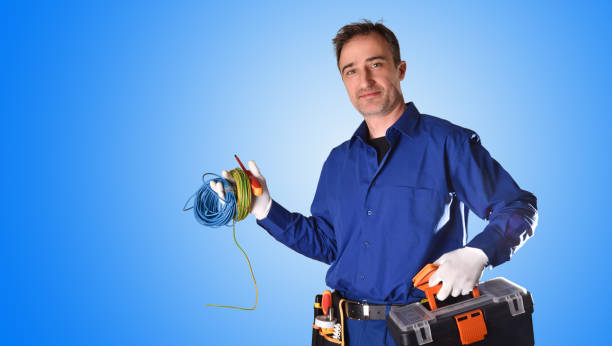 istock Uniformed electrician with tools and electrical equipment blue background 1130957856