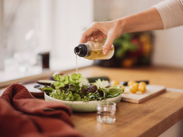 istock Woman preparing healthy salad in kitchen 1130961411