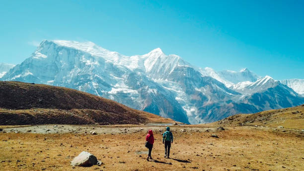 Nepal - Couple and the view on Annapurna ChainNepal "A couple walking towards the Ice lake, as part of the Annapurna Circuit Trek, Himalayas, Nepal. Annapurna chain in the back, covered with snow. Clear weather, dry grass, snowy peaks. High altitude
" annapurna circuit photos stock pictures, royalty-free photos & images