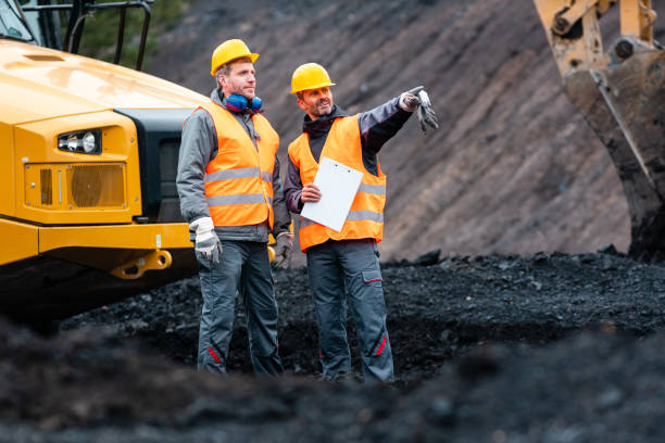 istock Worker with a plan and a clipboard discussing things in quarry 1130965301