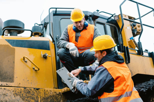 istock Worker with heavy excavation machinery in mining operation 1130965877