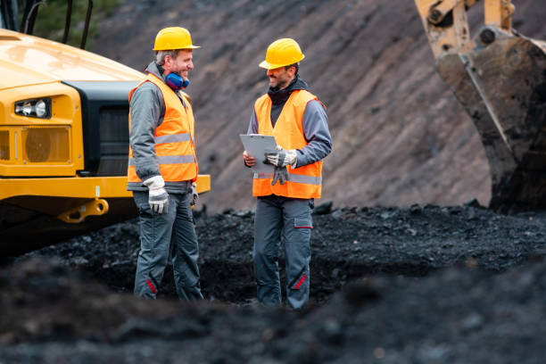 arbeiter mit plan und zwischenablage, die dinge im steinbruch besprechen - surface mine stock-fotos und bilder