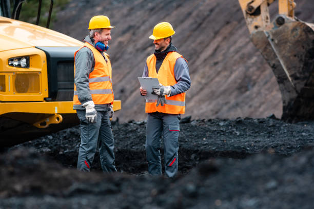 Worker with a plan and a clipboard discussing things in quarry Worker with a plan and a clipboard discussing super important things in quarry open pit mine photos stock pictures, royalty-free photos & images