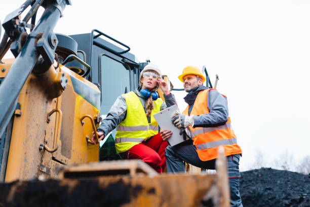 istock Woman and man worker in quarry on excavation machine 1130966057