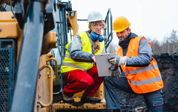 istock Woman and man worker in quarry on excavation machine 1130966162