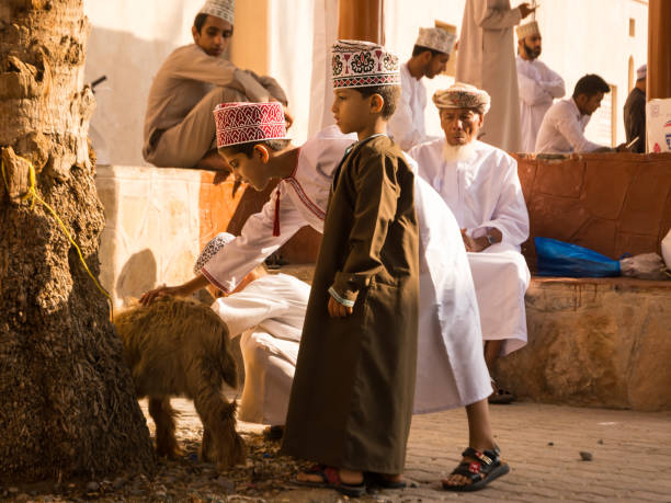 оманский дети играют с животными на рынке nizwa пятницу - nizwa стоковые фото и изображения