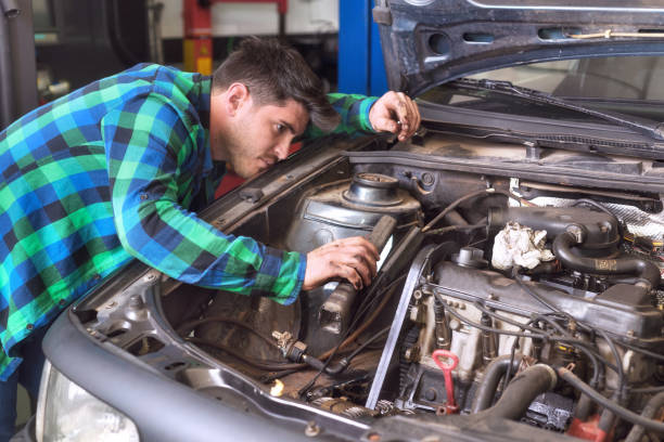 istock Handsome mechanic talking on the phone while repairing a car . 1130966773