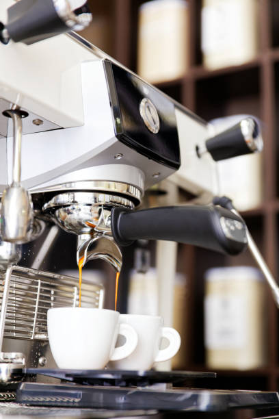 istock Coffee brewing in coffee machine. Espresso pouring in two cups. 1130971368
