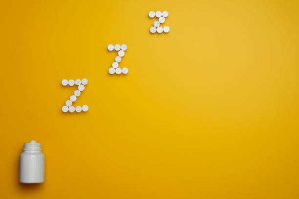 istock Pills. Hypnotic sedative pills. Tablets on yellow background. 1130972533