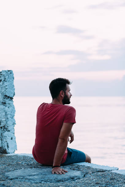 istock Young man enjoying blue hour by the sea 1130972998