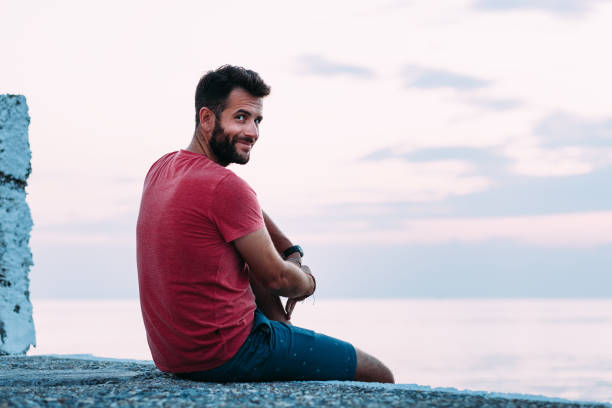 istock Young man enjoying blue hour by the sea 1130973003