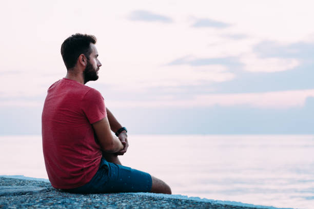 istock Young man enjoying blue hour by the sea 1130973013