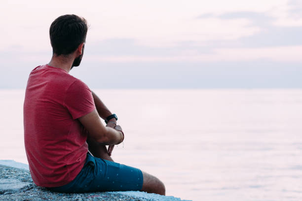 istock Young man enjoying blue hour by the sea 1130973017