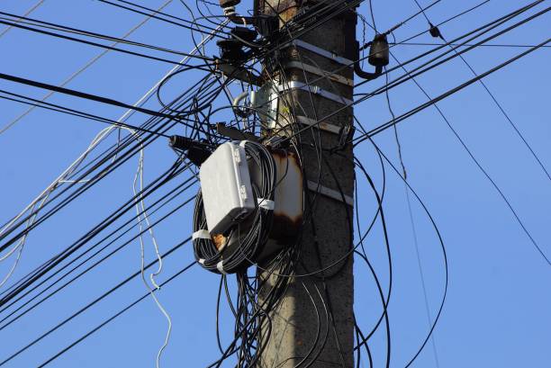 istock gray concrete pole with a box and black wires against a blue sky 1130974343
