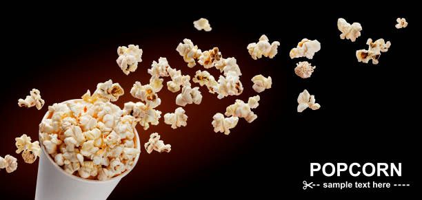 Popcorn in cardboard box Popcorn in cardboard box, isolated on black background with copy space popcorn snack bowl isolated stock pictures, royalty-free photos & images